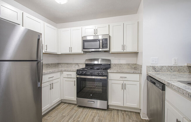 a kitchen with stainless steel appliances and white cabinets at North Pointe Apartments in Elkhart, IN