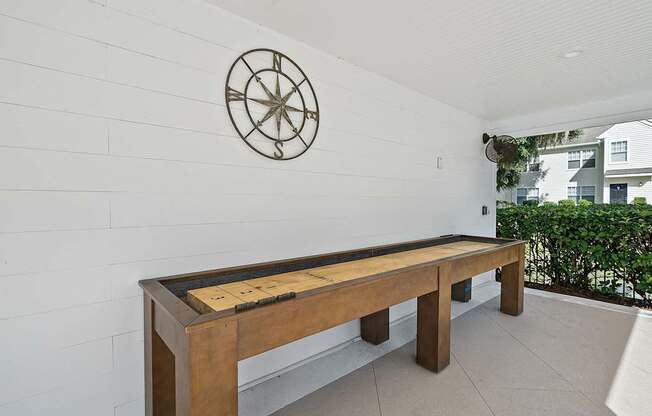 A long wooden table with a compass on the wall.