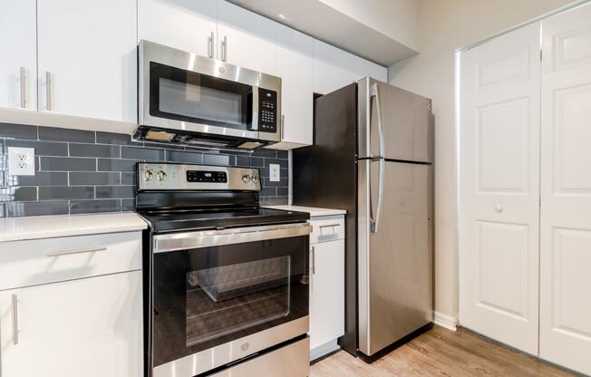 a kitchen with white cabinets and stainless steel appliances at Heritage Bay, Jensen Beach, FL