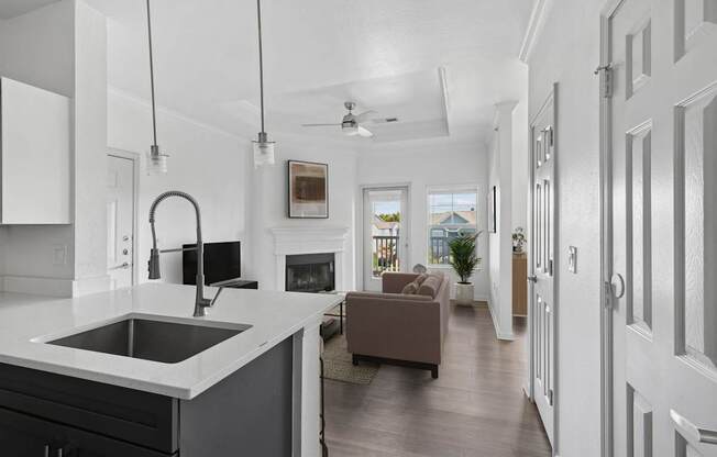 A modern kitchen with a large island and a fireplace in the living room.