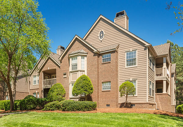 a brick apartment building with trees and grass at Radbourne Lake Apartments, Charlotte, 28269 ? 