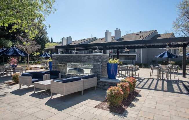 A patio with a fireplace and seating area at Kirker Creek Apartments, Pittsburg, California