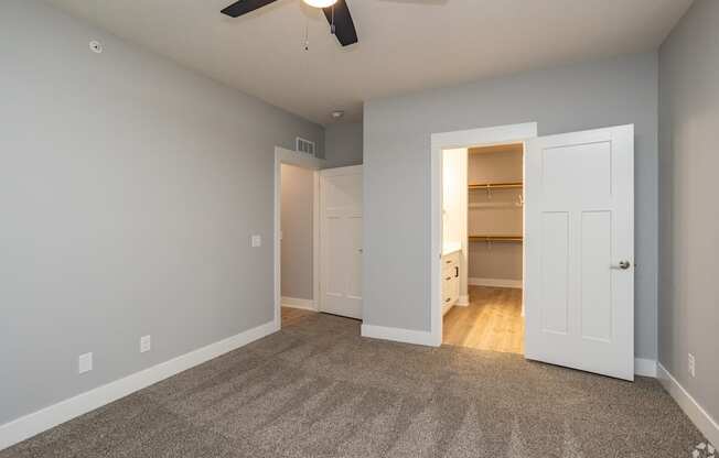 A room with a ceiling fan and a carpeted floor.