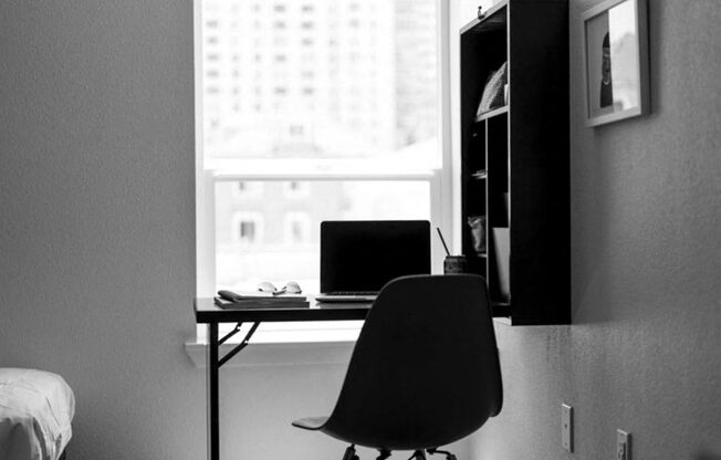 a black and white photo of a desk with a laptop