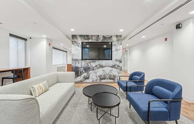 A living room with a grey couch, a blue chair, and a black table.