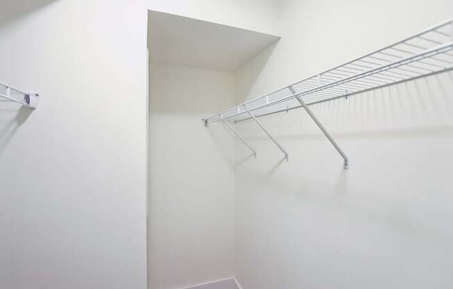 A white closet with a metal racks.
