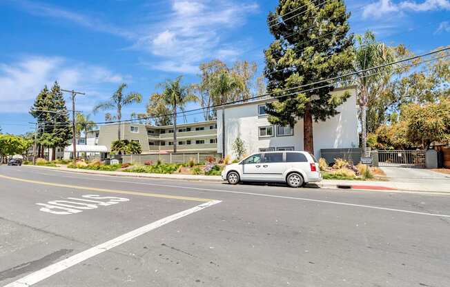 A white car is parked on the side of the road.
