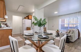 a living room with a table and chairs and a kitchen