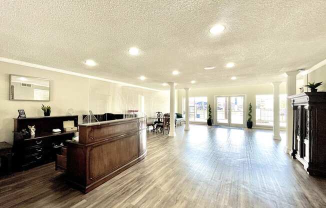 a lobby with a reception desk and a large room with hard wood floors at Cambridge Village Apartments, Texas ? 
