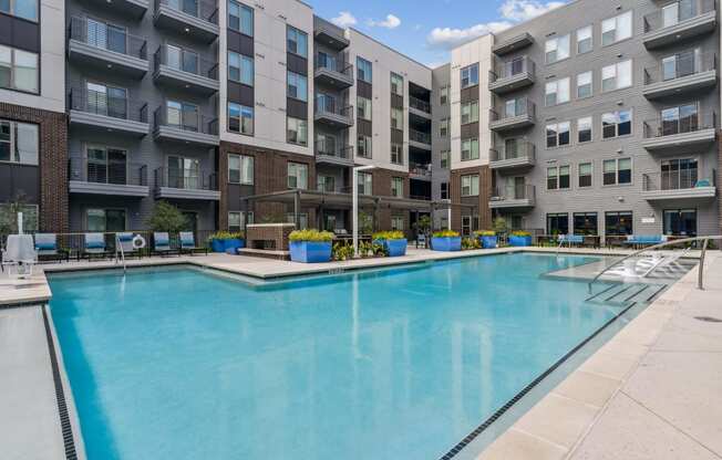 an apartment swimming pool in front of an apartment building