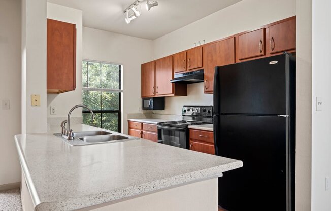 a kitchen with a white counter top and black appliances