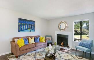 A living room with a brown couch, a coffee table, and a painting on the wall.
