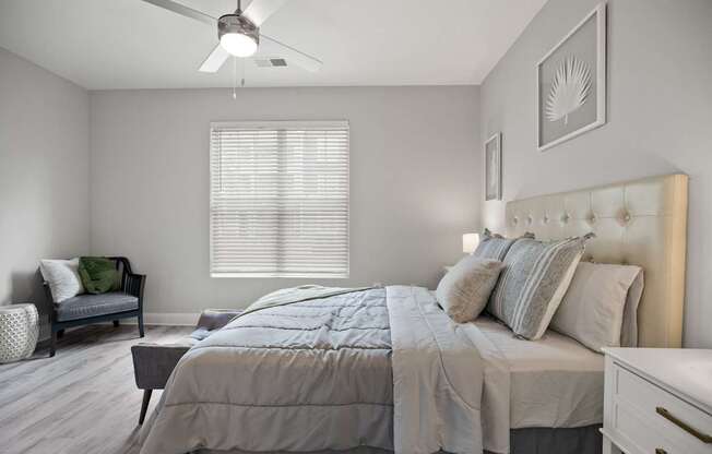 A bedroom with a bed, dresser, and chair.