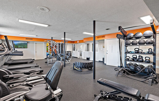 A gym with a variety of equipment including weights and machines.