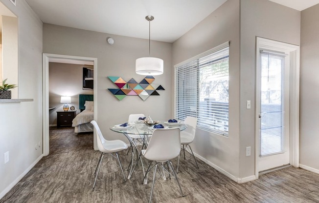 A dining room with a white table and chairs.