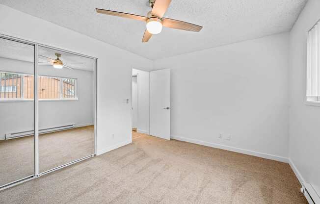 a bedroom with a ceiling fan and a mirror