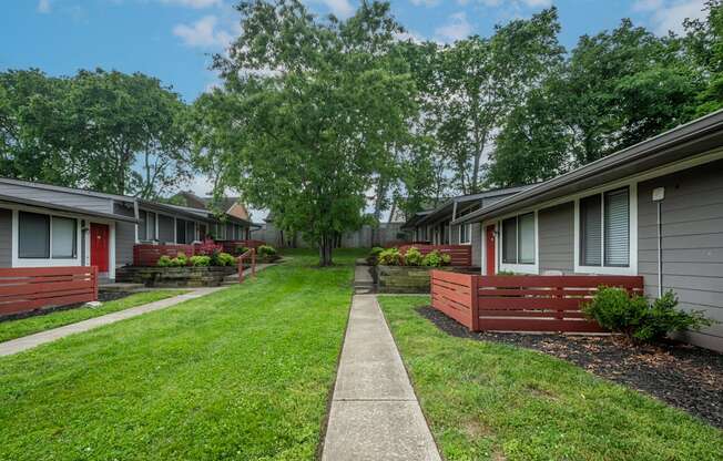 A row of studio and one bedroom apartments at The Retreat at Indian Lake with green lawns and trees in the background.
