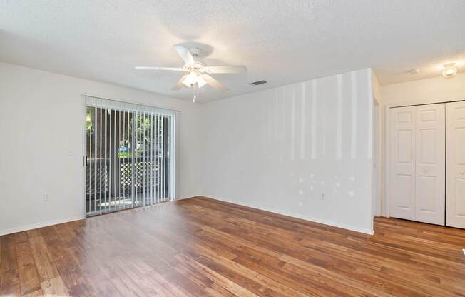 A room with wooden floors and a ceiling fan.