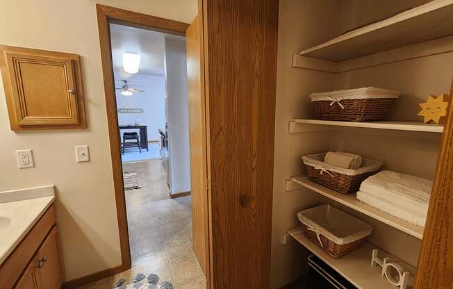 A kitchen with a pantry door open to a living room.