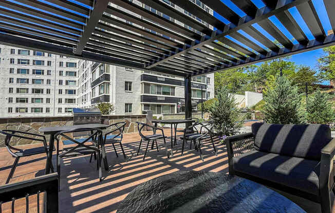 A patio with a striped couch and a table with chairs.