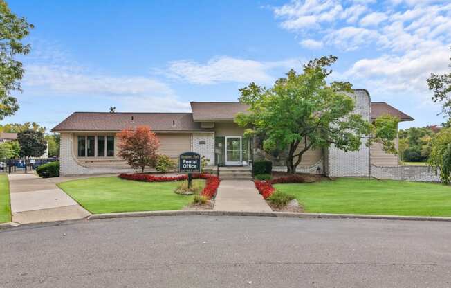 the front of a house with a green lawn and a driveway