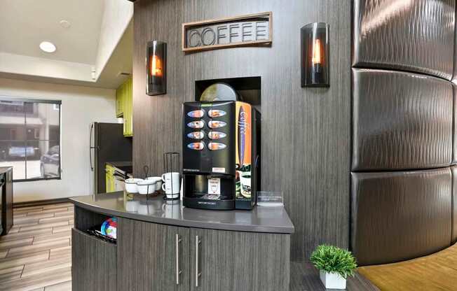 A coffee machine is on a counter with a sign above it that says "COFFEE".