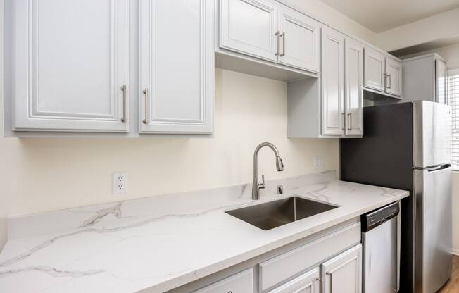 a kitchen with white cabinets and a sink