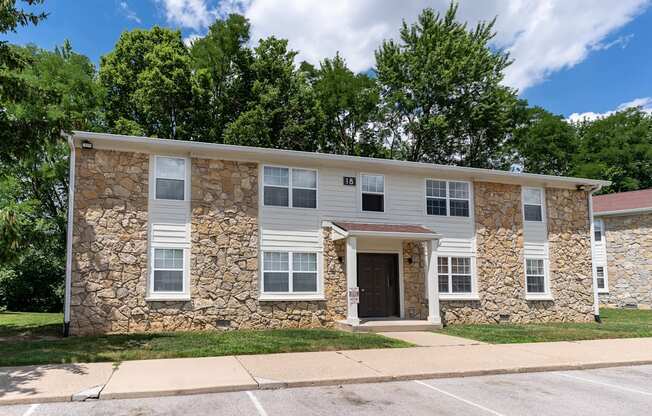 a white building with a stone facade and a sidewalk