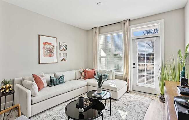 A living room with a white couch, a coffee table, and a rug.