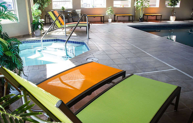 a pool area with lounge chairs and a plunge pool