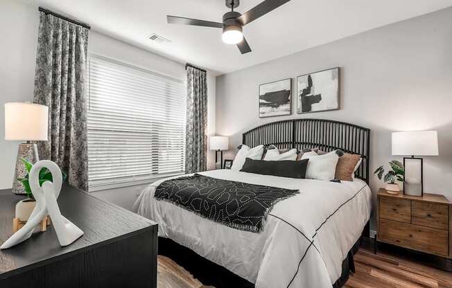 A bedroom with a bed, nightstand, and a ceiling fan.
