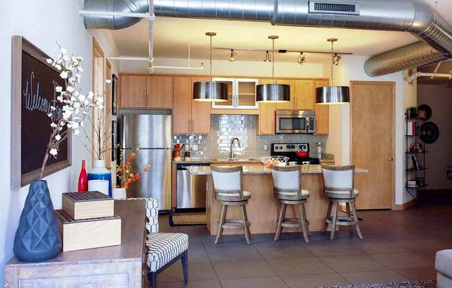 A kitchen with a refrigerator, microwave, and oven.