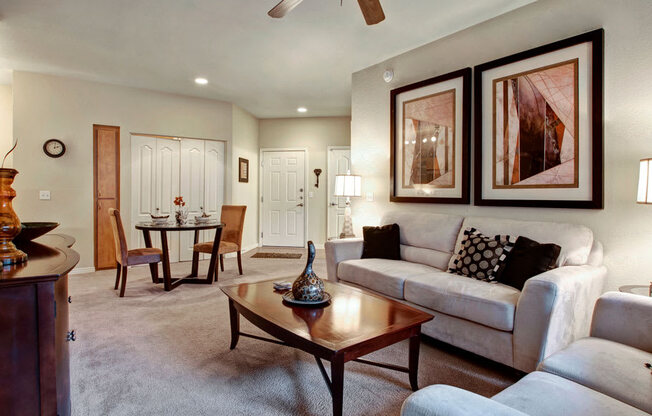 a living room filled with furniture and a ceiling fan