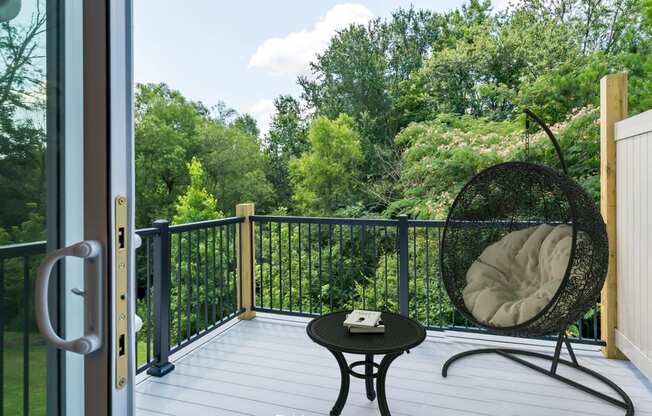 a balcony with a chair and a view of the woods