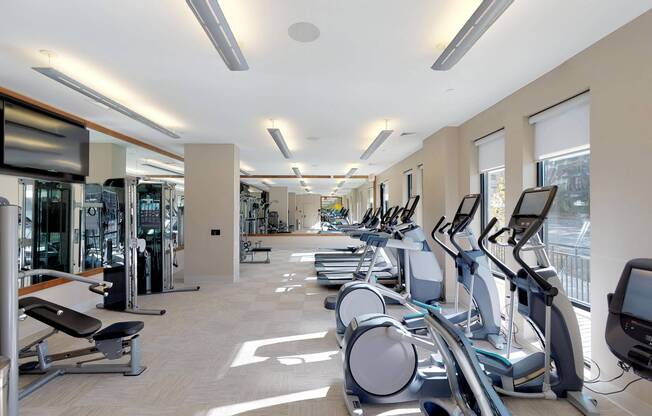 Brightly lit fitness center featuring floor to ceiling windows