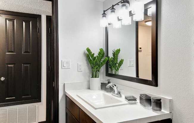 a bathroom with a sink and a mirror at The Lorient Apartments, Pensacola, Florida