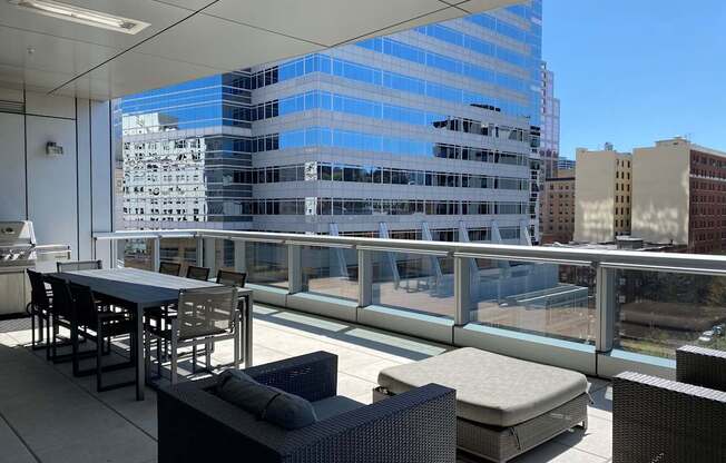 A patio with a table and chairs overlooking a cityscape.