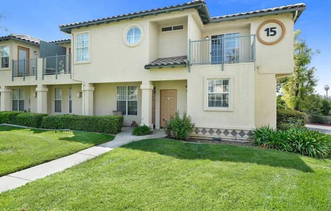 a house with a lawn and a sidewalk in front of it