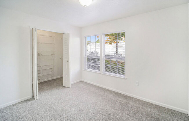 an upgraded bedroom with a walk in closet and a window at Black Sand Apartment Homes in Lincoln, NE