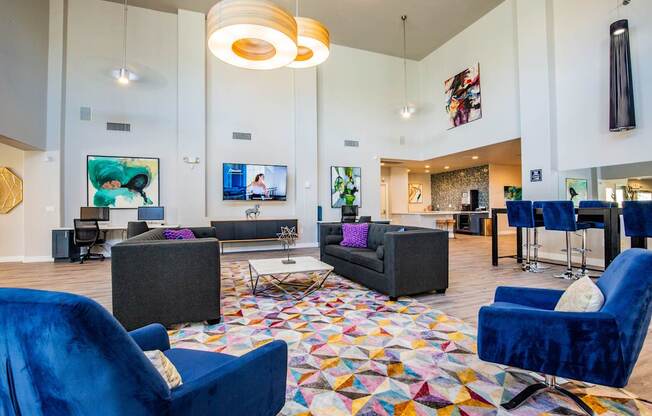 A living room with a blue chair and a colorful rug.