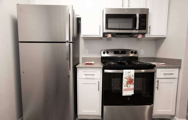 a kitchen with stainless steel appliances and white cabinets