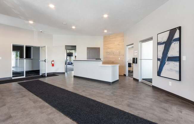 A reception area with a white reception desk and a black carpet.