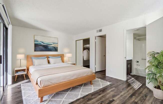 A bedroom with a large bed and a painting on the wall.