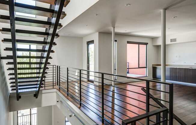 A modern interior with a spiral staircase and a balcony.