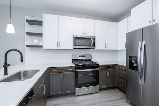 A modern kitchen with stainless steel appliances and white cabinets.