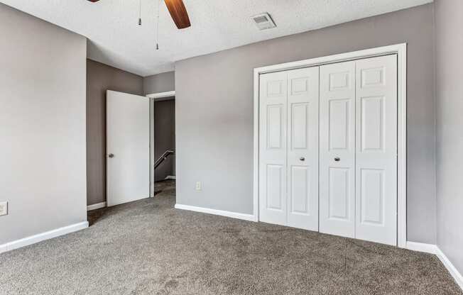 Whitney Manor Apartments in Gretna, LA photo of bedroom with plush carpeting and ceiling fan