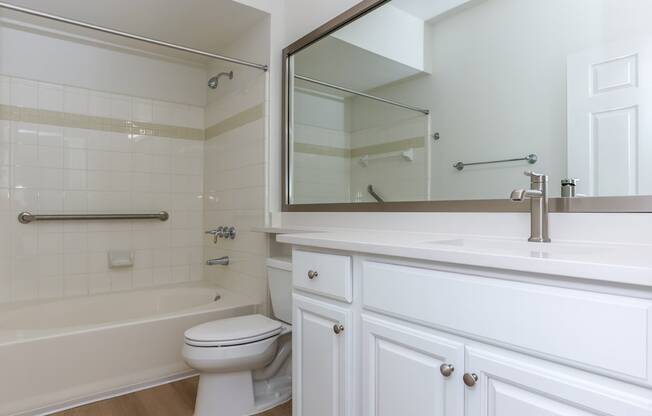 A white bathroom with a toilet, sink, and bathtub.