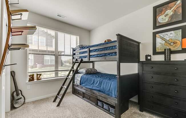 a bedroom with bunk beds and a guitar on the wall