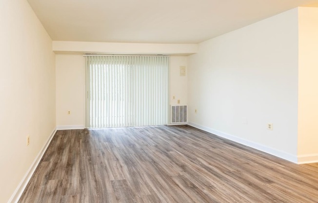 a bedroom with hardwood floors and white walls