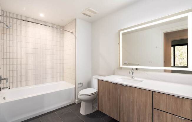 A white bathroom with a tub, toilet, and sink.